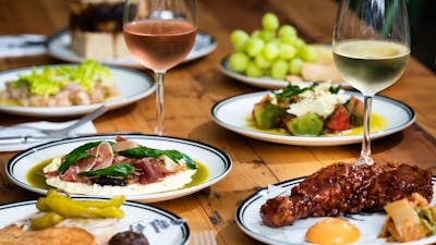 Table of delicious foods with glasses of rosé and white wine.