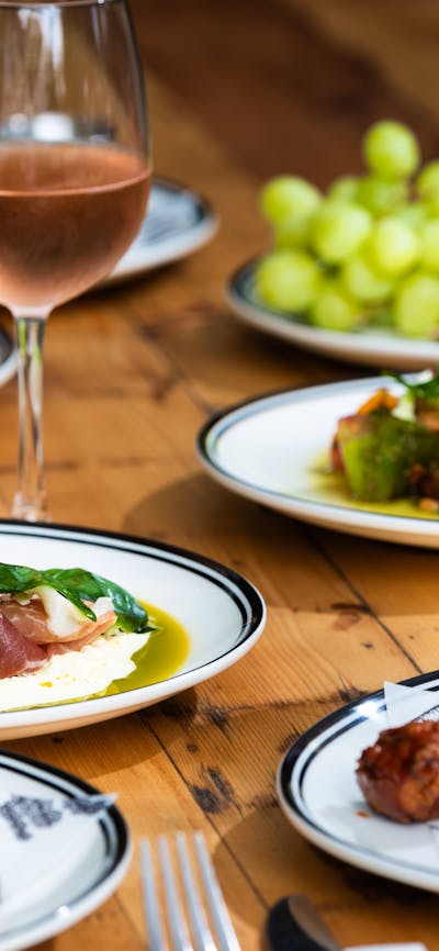Table of delicious foods with glasses of rosé and white wine.