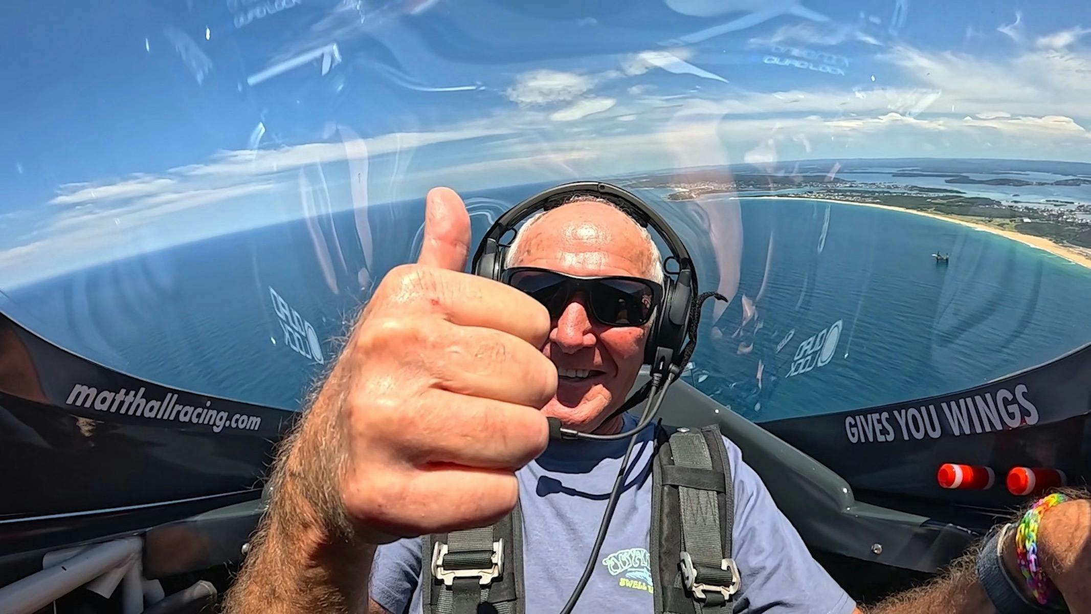 Matt Hall Racing aerobatic joy flight passenger thumbs up mid-flight near Lake Macquarie Airport NSW