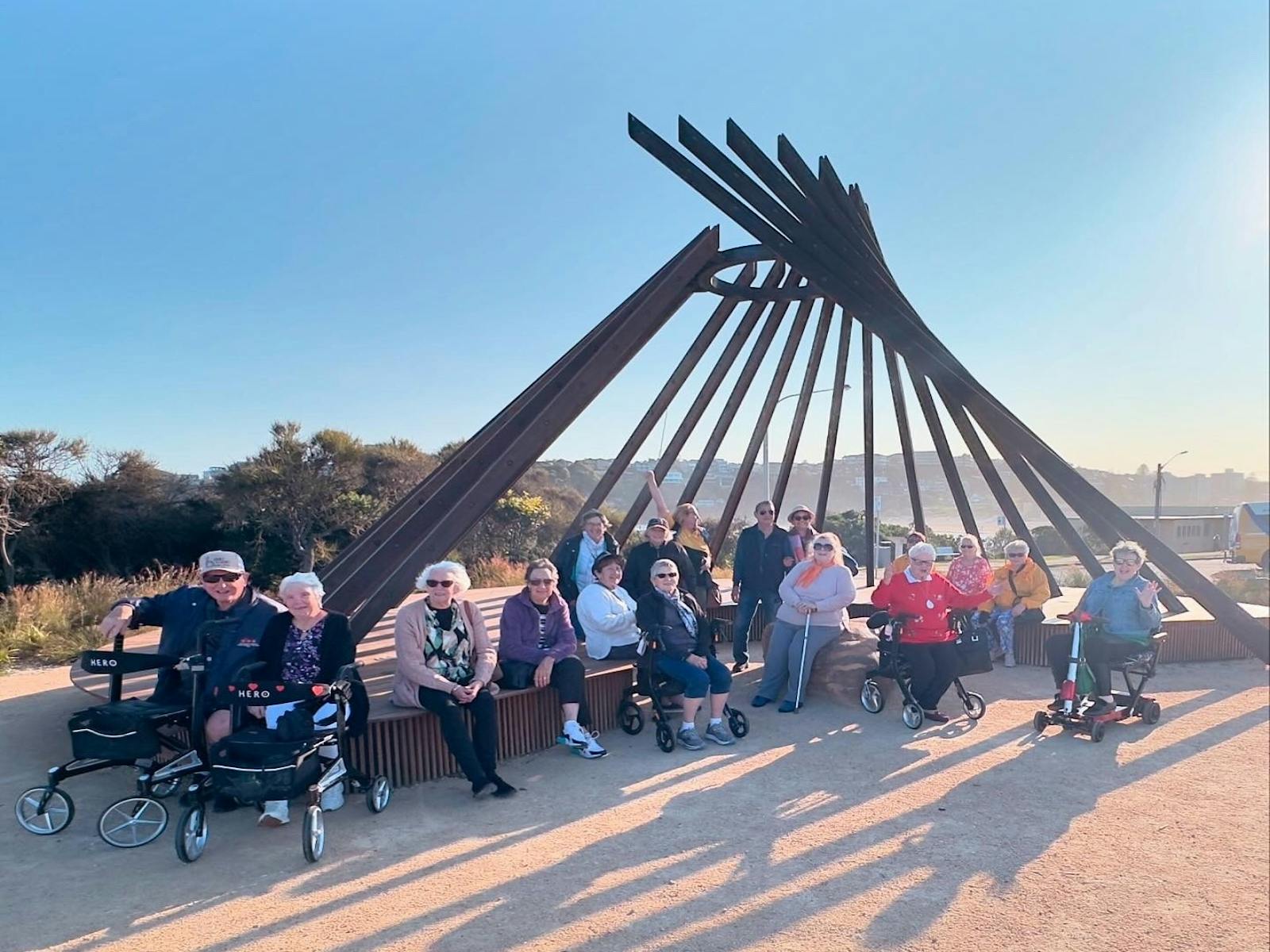 Large group on Accessible Tour, sitting under Signal Fire monument.