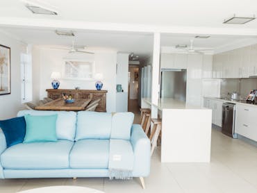 alt text=view of lounge through other kitchen and dining