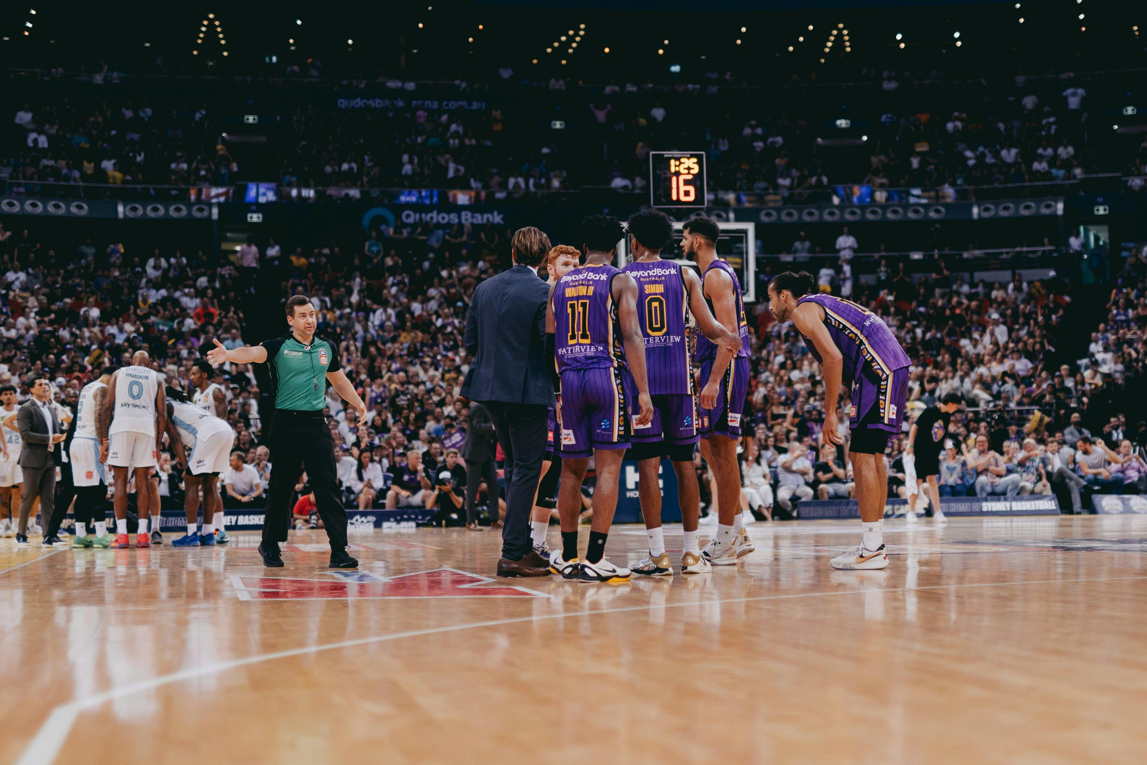 Players gather midcourt during a Sydney Kings game