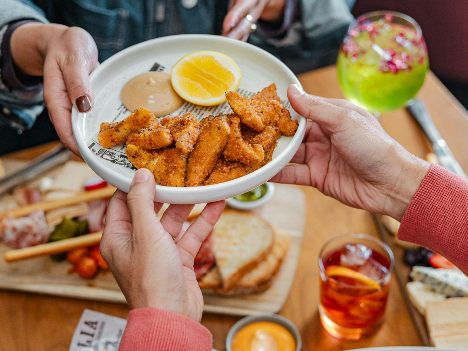 Hand passing plate of salt & pepper squid