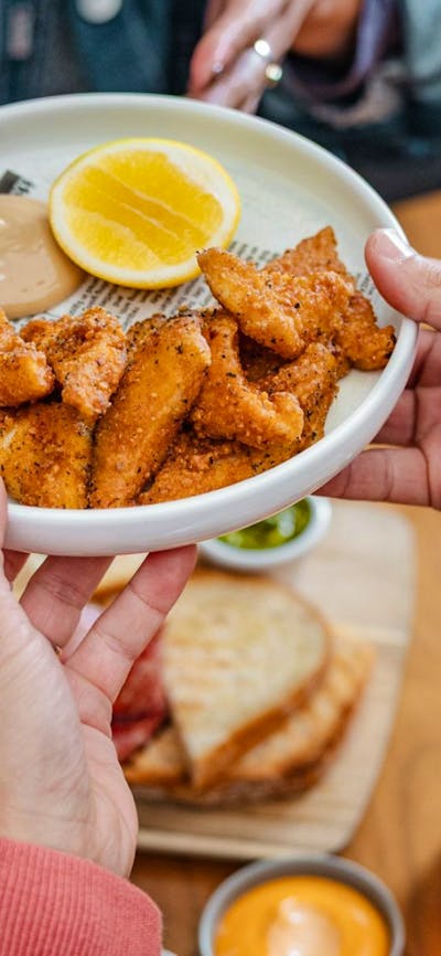 Hand passing plate of salt & pepper squid