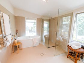 Bathroom with freestanding bath, shower (no door for limited mobility access), and toilet.