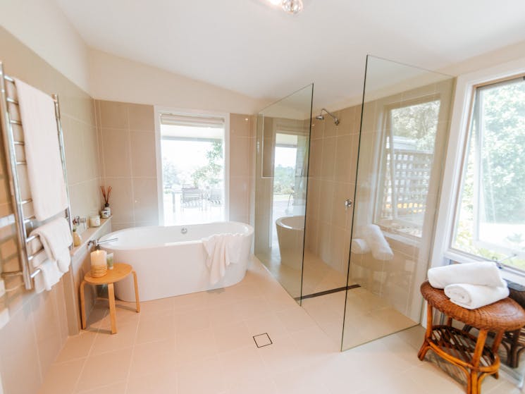 Bathroom with freestanding bath, shower (no door for limited mobility access), and toilet.
