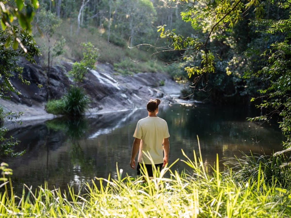 A man overlooks a creek in Julatten, Mareeba Shire