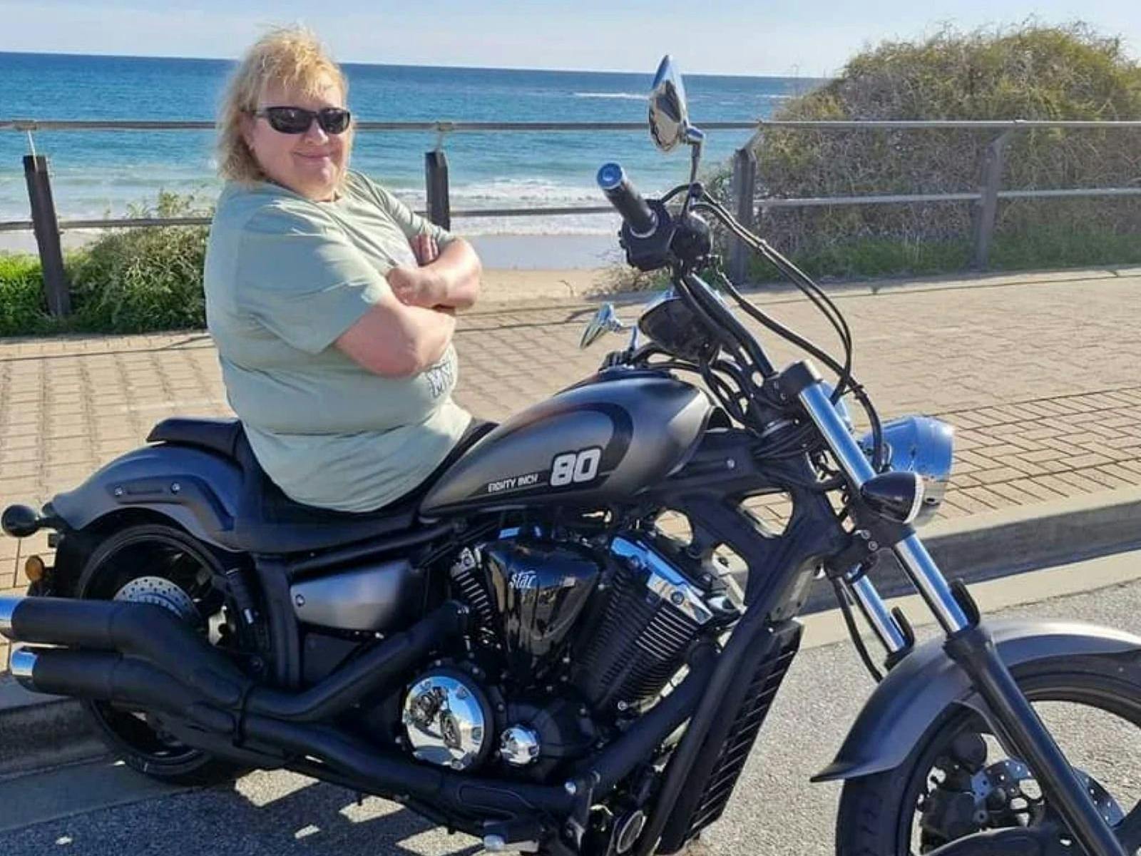 woman smiling while sitting on motorcycle