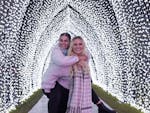 Two friends giving each other a piggy back in a light tunnel at Festival of W