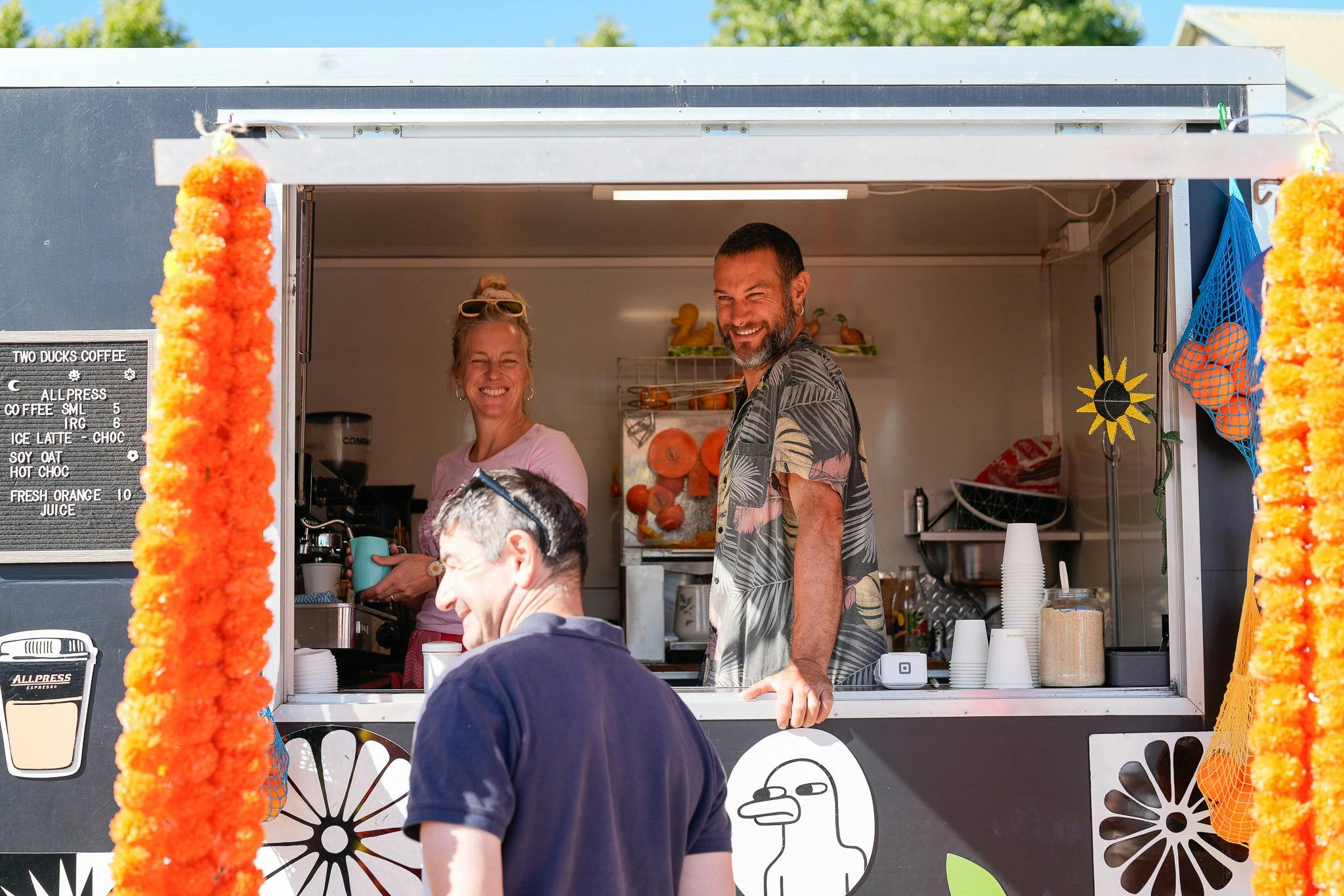 The Two Ducks coffee stand serving a customer