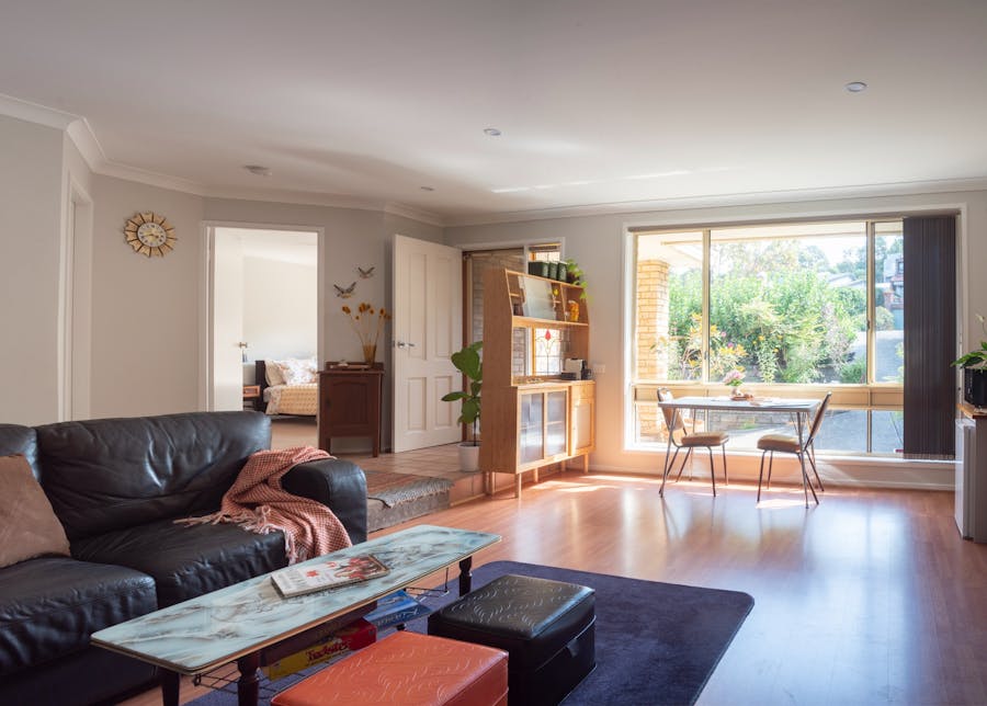 Large sun-lit room with lounge, coffee table, smart TV and Kitchenette.