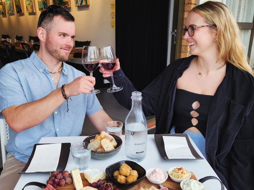 Couple dining with wine and grazing board laughing