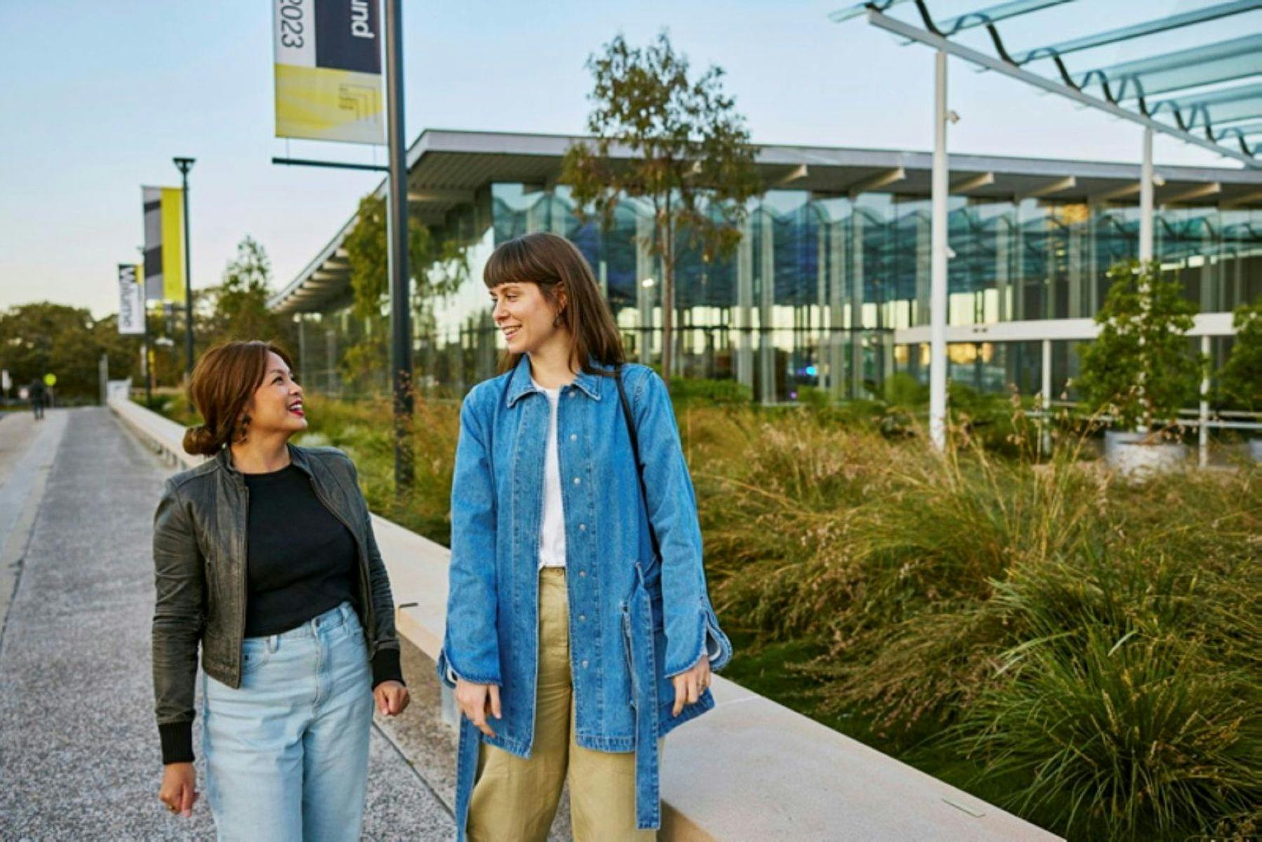 Two women standing on a sidewalk
