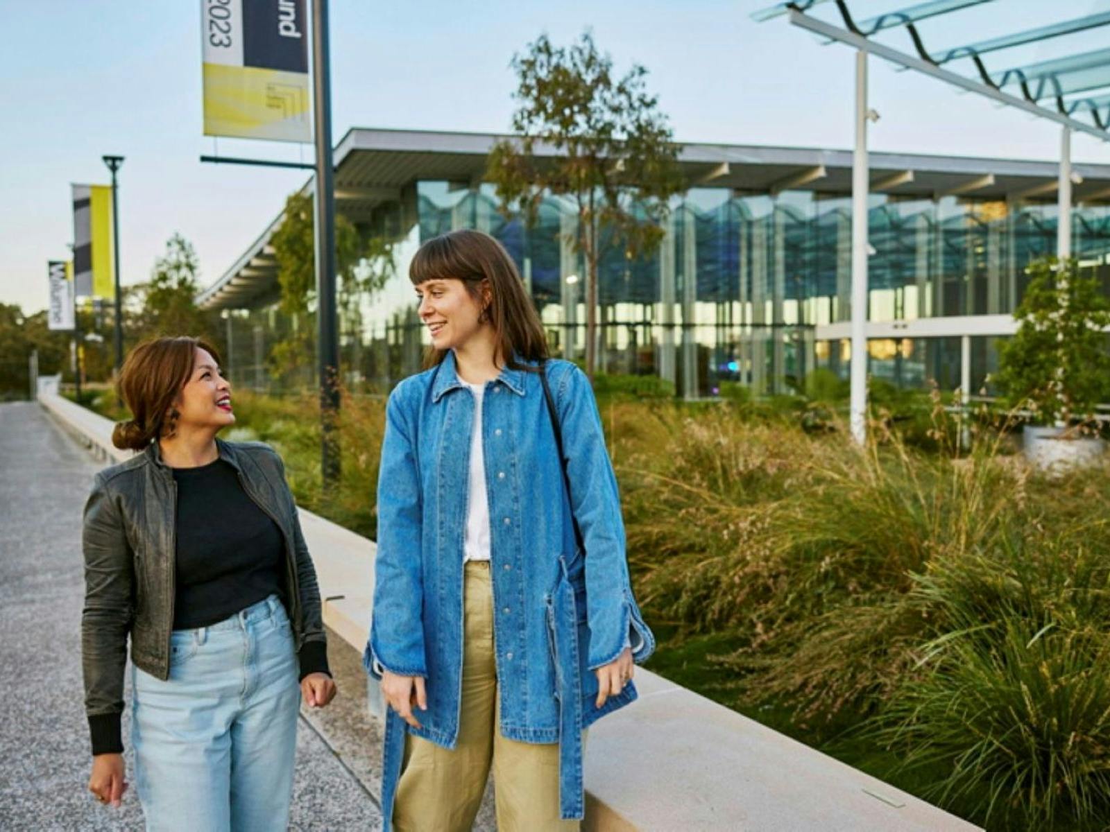 Two women standing on a sidewalk