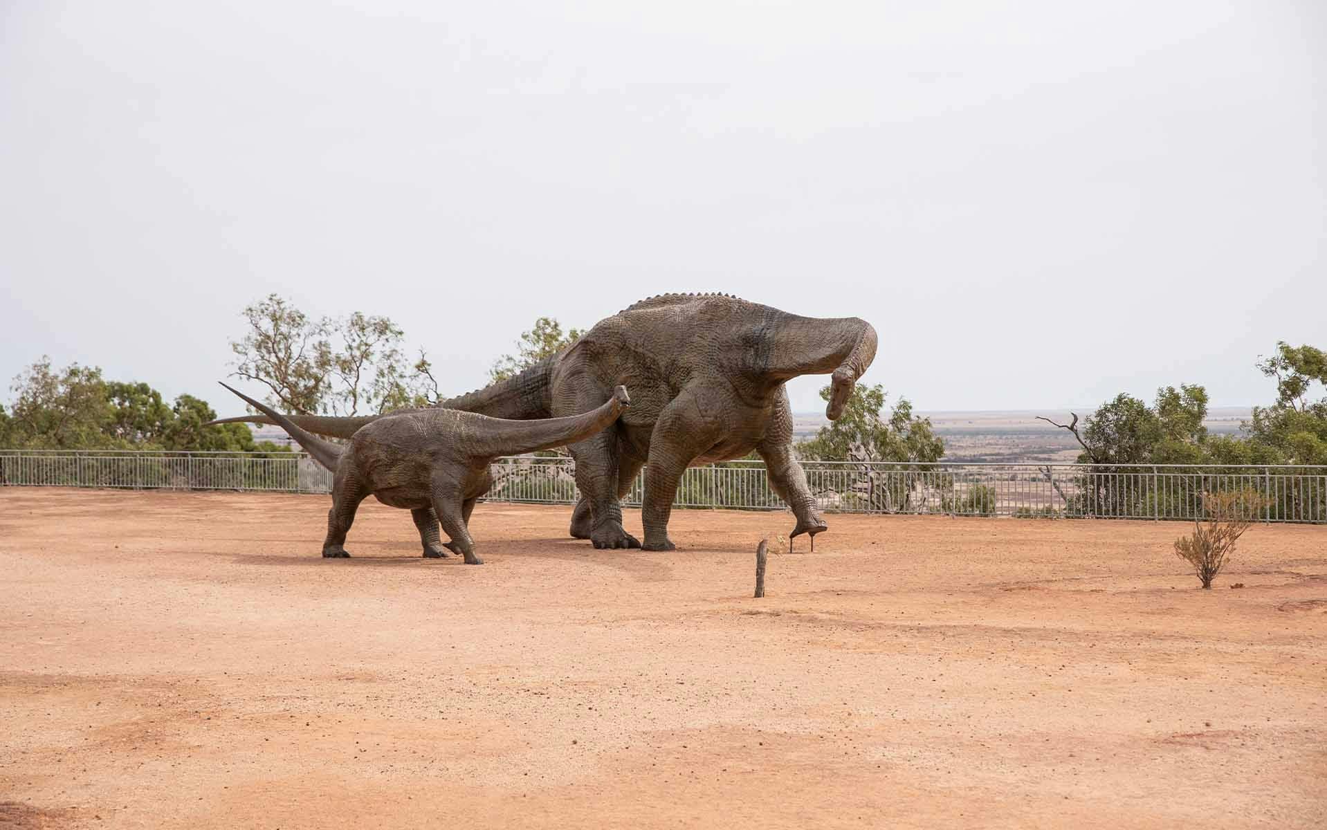 Two dinosaur statues standing next to each other