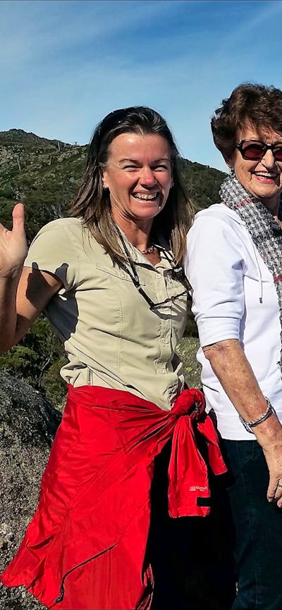 Four seniors and tour guide at Charlotte pass lookout with Mount Kosciuszko behind