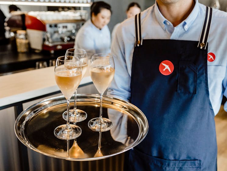 Server holding a tray of Swift Sparkling