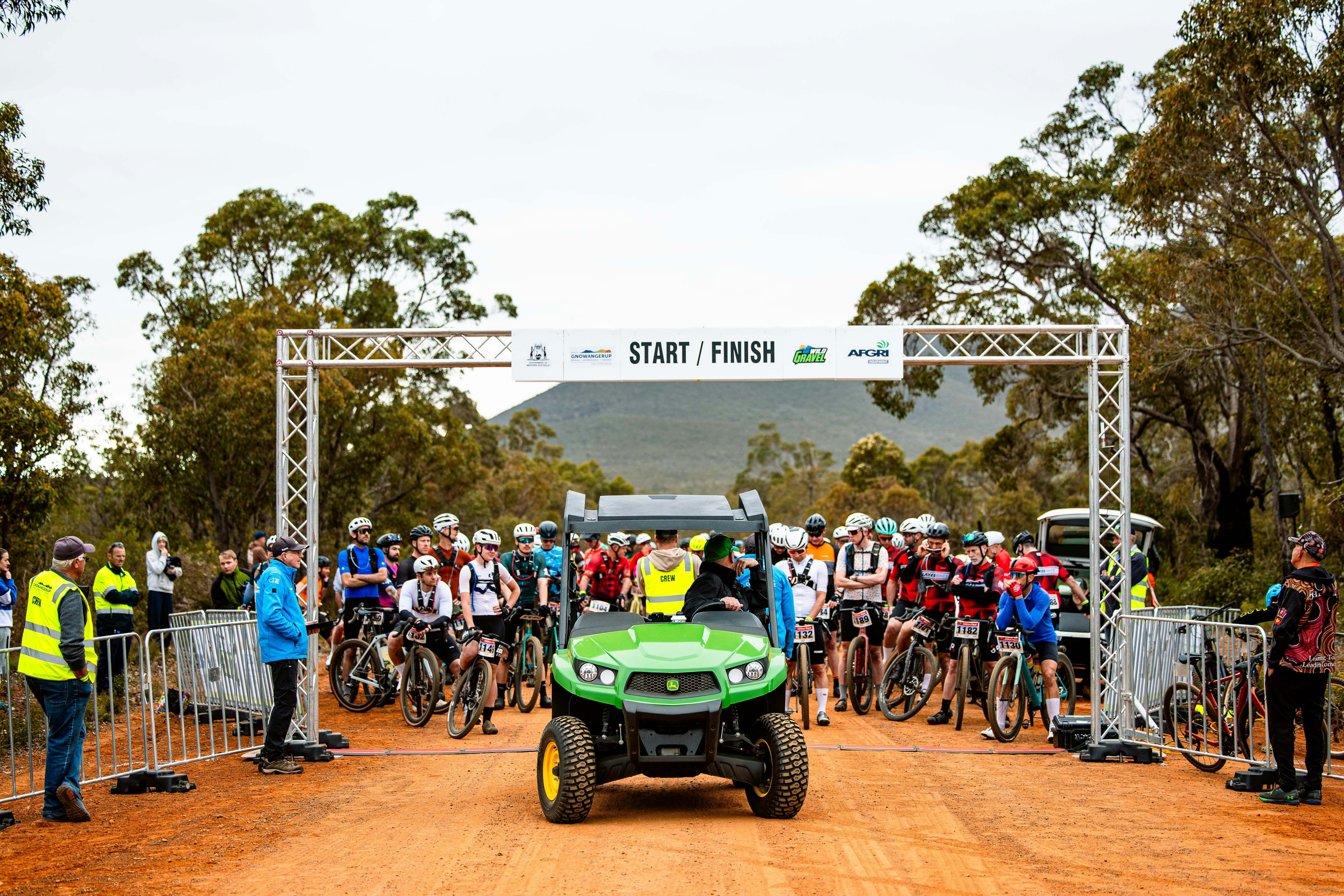 Start line arch, gravel cyclists gathered, Afgri gator buggy in front