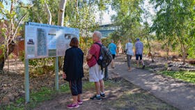 Visitors Centre entrance, Grey nomads featured looking at sign