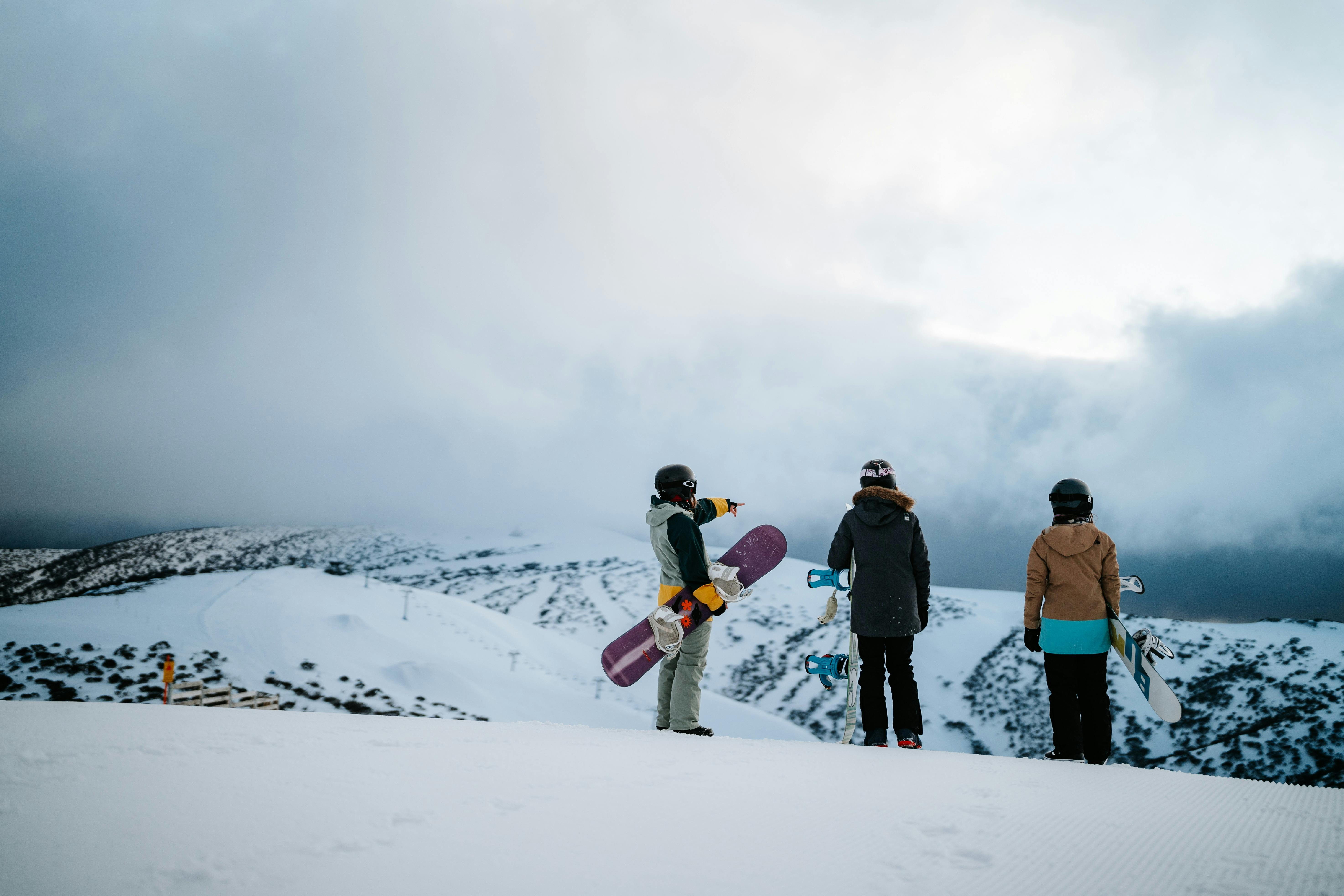Snowboarders taking in the views from a snowy Mt Hotham