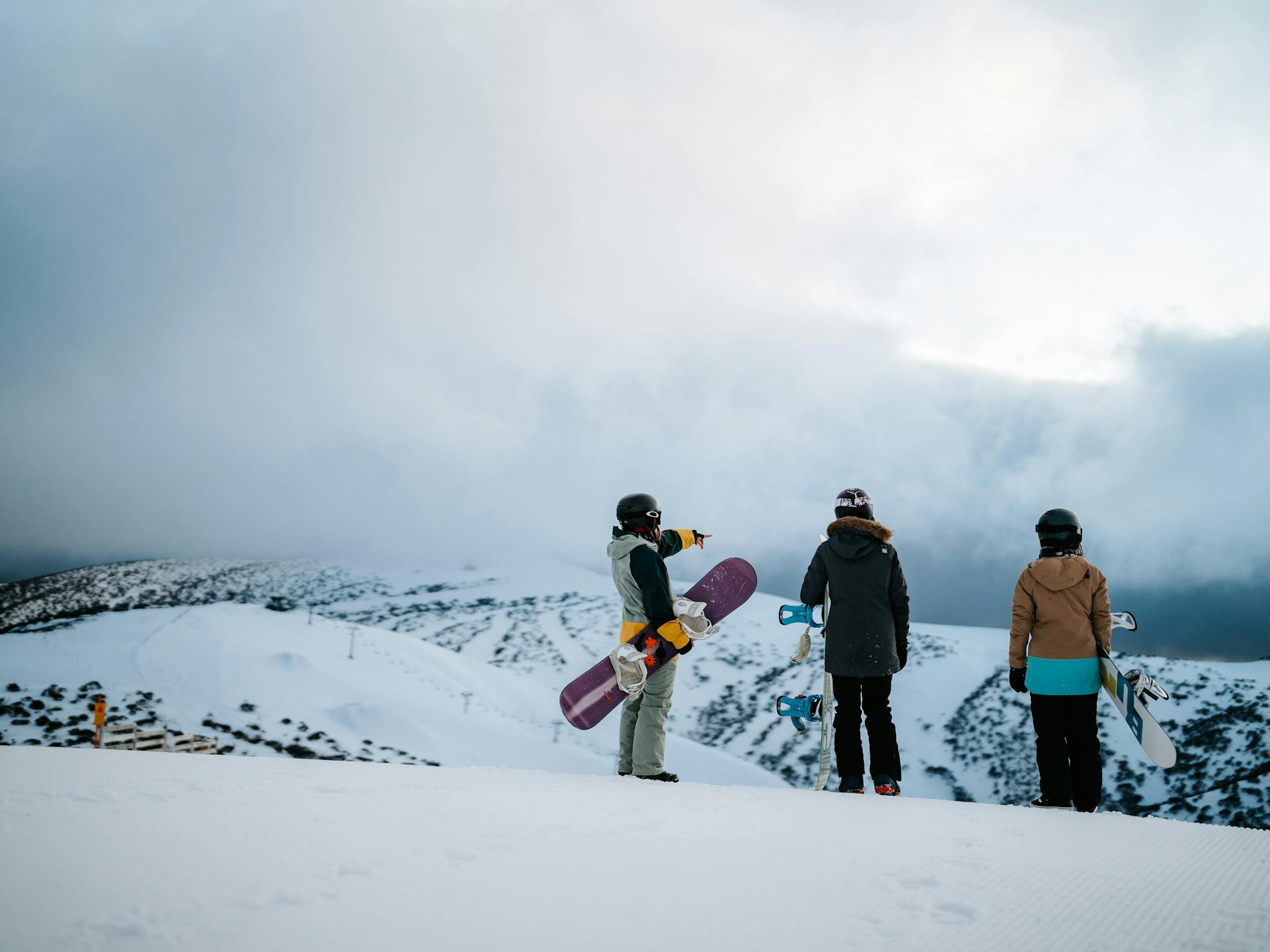 Snowboarders taking in the views from a snowy Mt Hotham