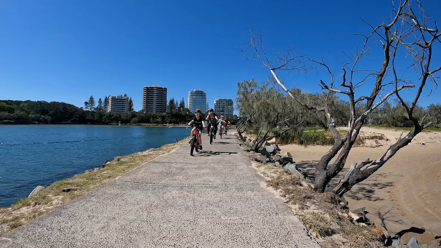 Family riding e-Bikes Mooloolaba Spit Rock Wall