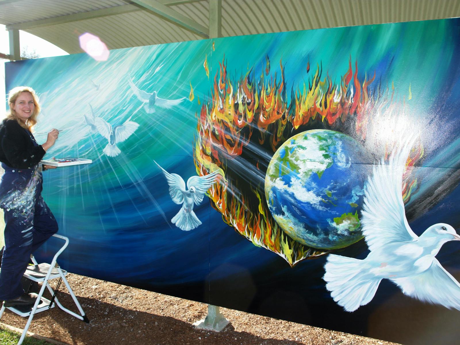 An International Mural Fest entrant works on her piece, in Mural Park during International Mural Fes