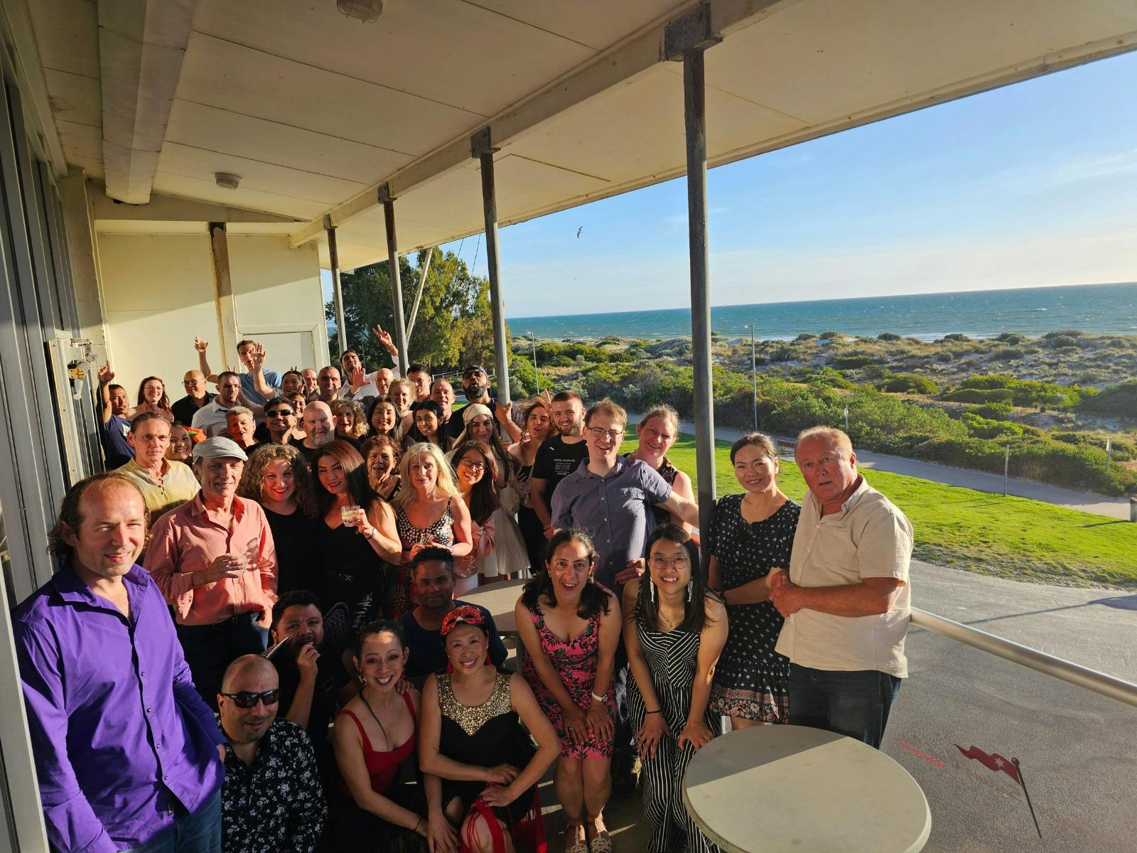 Attendees taking a group photo at our Salsa by the Sea Event