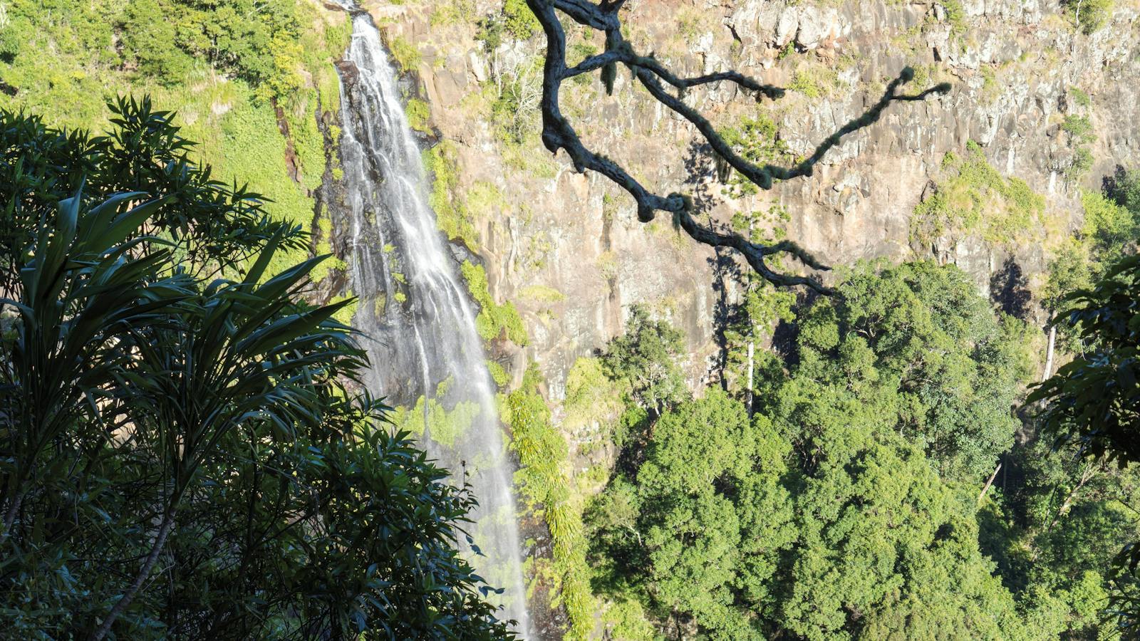 Waterfall tumbling over rocky cliff face.