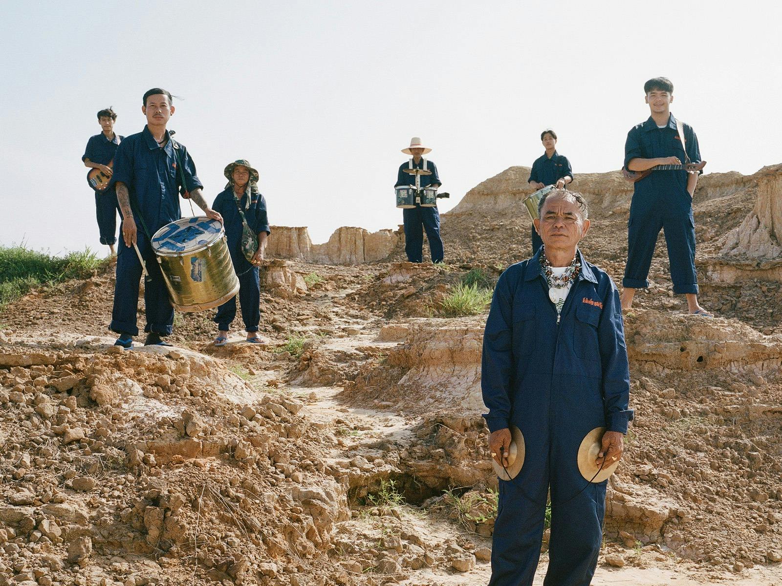 Khun Narin standing in desert with instruments