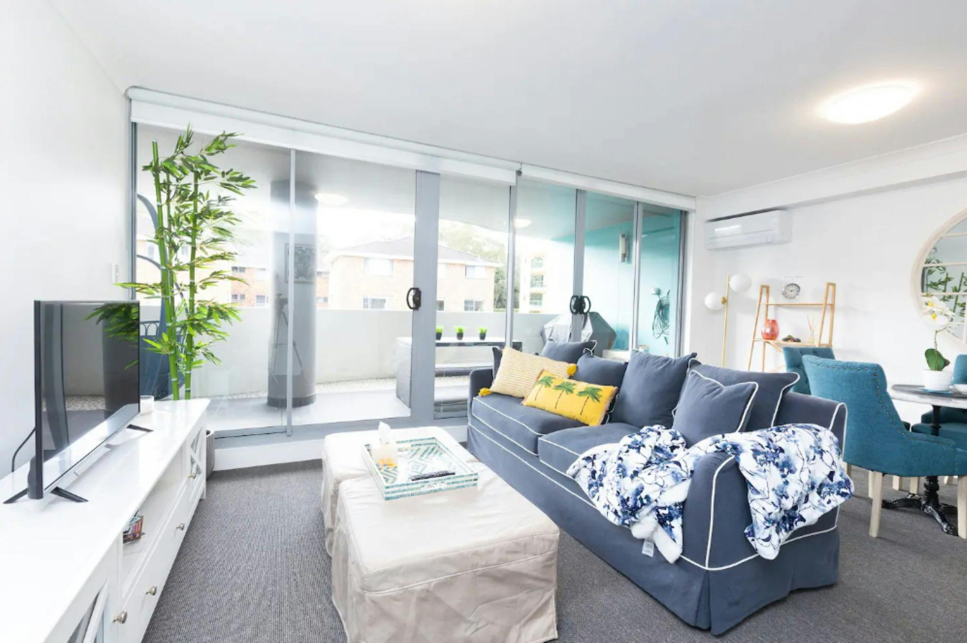 Living area leading with bright coastal decor, leading out to furnished balcony