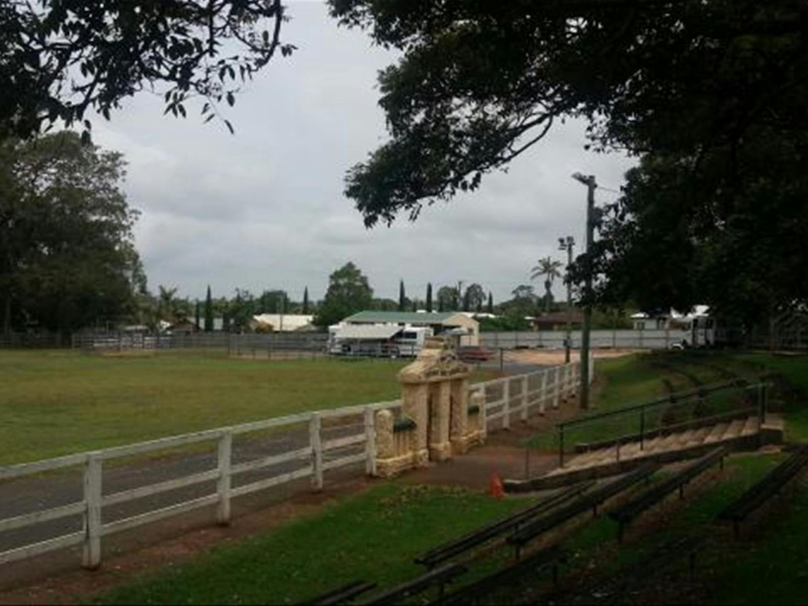 Image of a showground surrounded by a white fence and trees