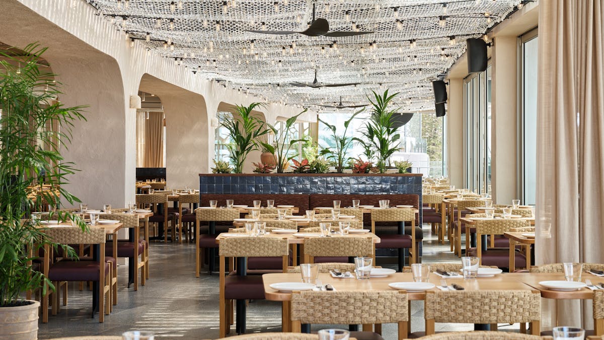 Rows of beautiful tables and chairs with wood crafted finishes in Hurricane's Surfers Paradise.