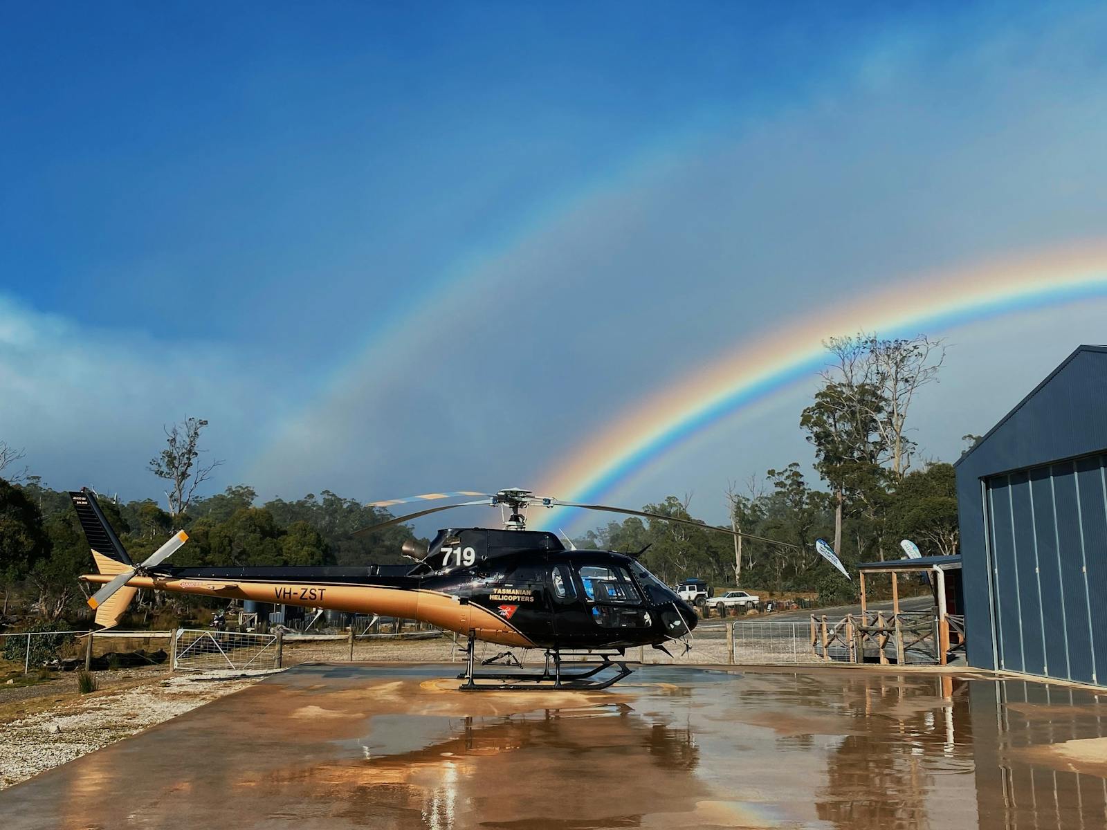 Our black & gold B2 Squirrel Helicopter on our concrete helipad, with a rainbow in the background