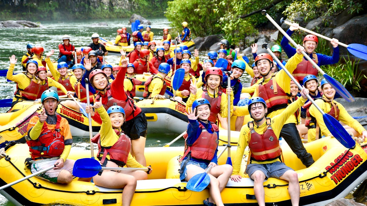 Huge Group photo of all rafting boats waving near Ponytail Falls on the Tully River