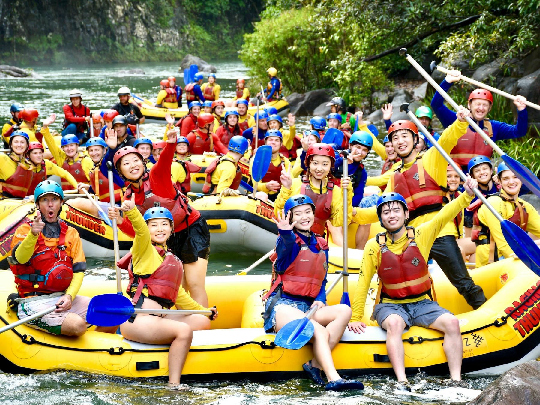 Huge Group photo of all rafting boats waving near Ponytail Falls on the Tully River
