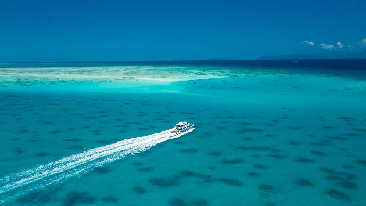 Ocean Freedom 20M stylish Motor Catamaran  across turquoise waters on way to Upolu Cay Reef