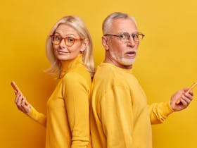 Mature couple dressed in yellow against a yellow background
