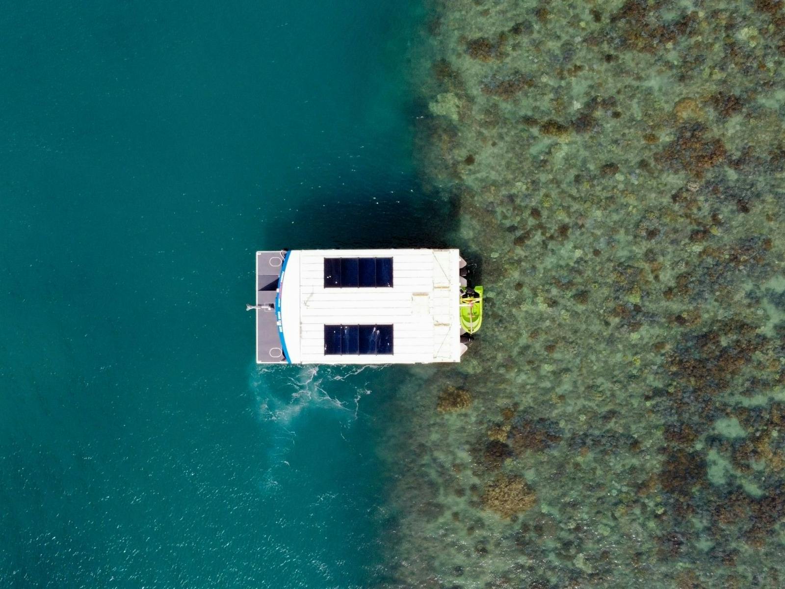 Birds eye view of the glass bottom boat sitting above reef edge Birds eye view of the glass bottom boat sitting above reef edge
