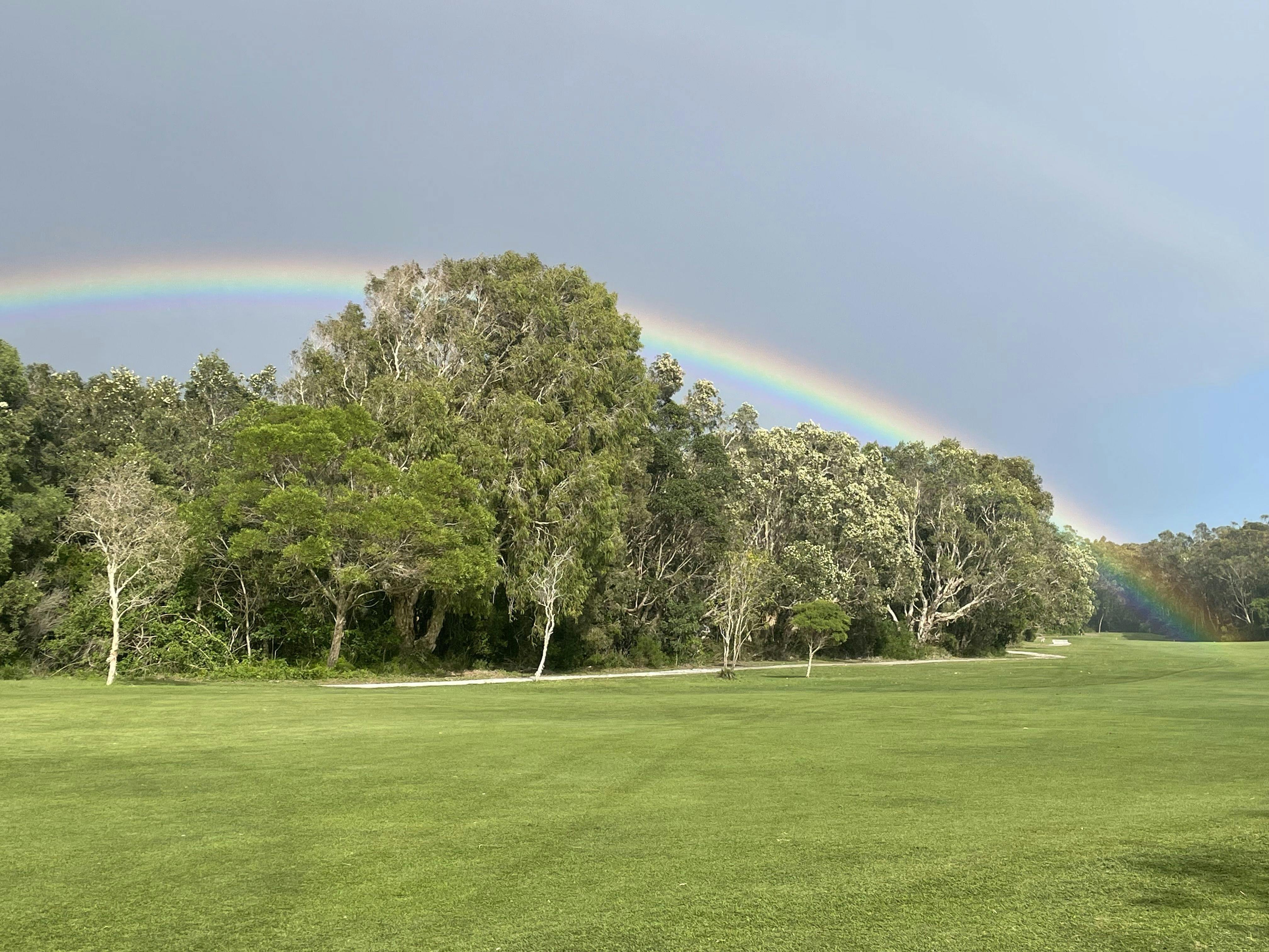 a beautiful rainbow arches over the treeline on one of Yamba's fairways