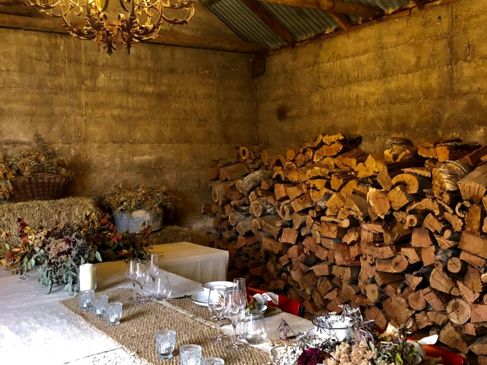 A cosy barn set up for evening meals under a beautiful chandelier