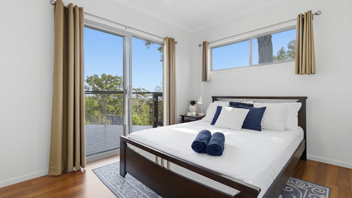 Comfortable bedroom with direct access to the outdoor deck and sunset and water views