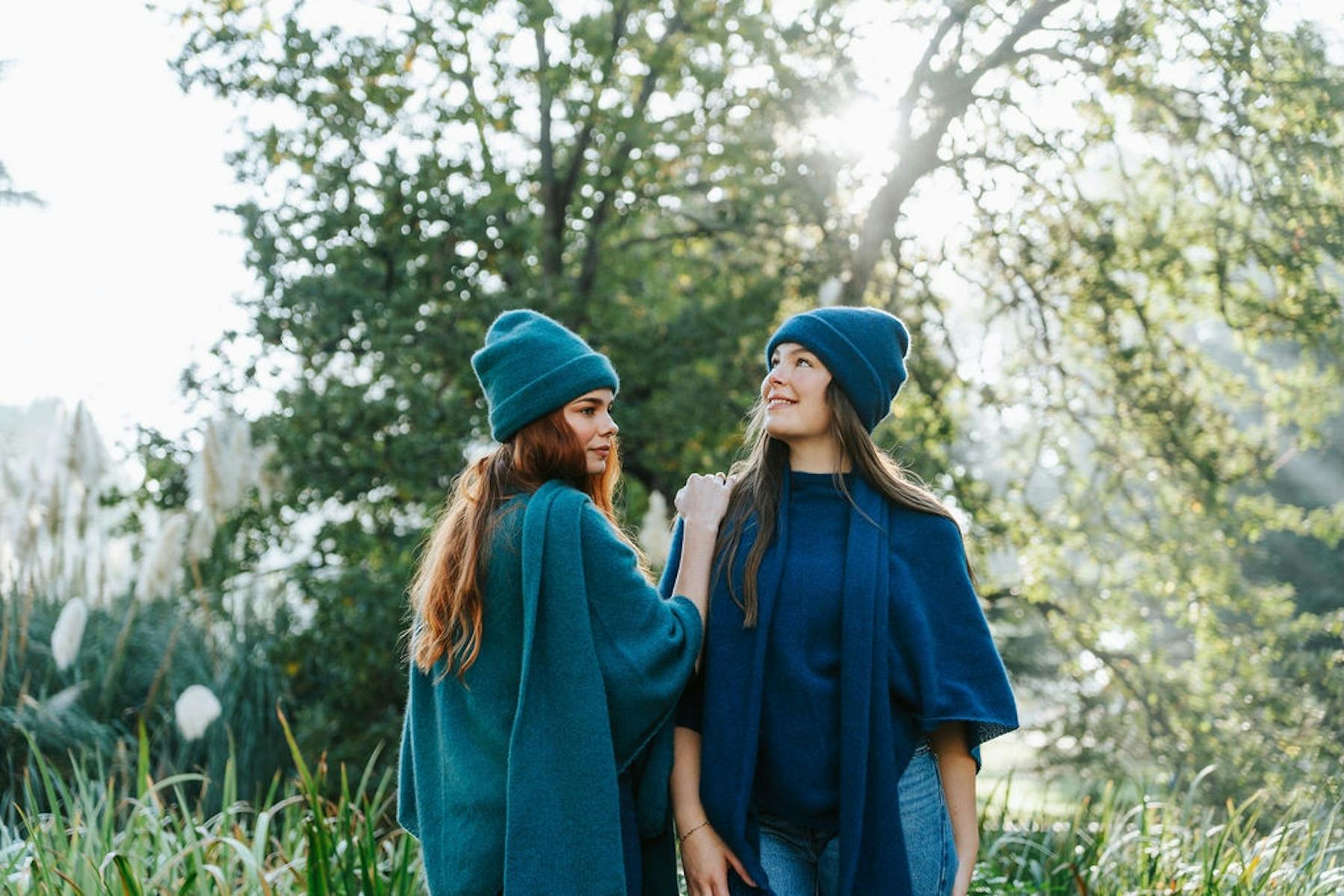 Two women wearing beanies and ponchos