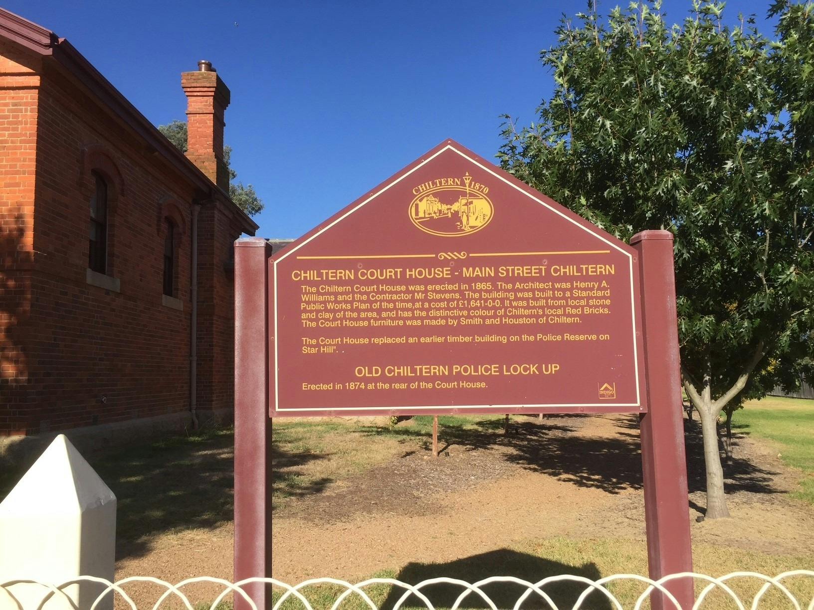 maroon painted sign with gold text