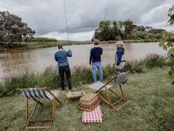 Fly Fishing Experience at Printhie Wines. Guests standing on edge of water with instructor.