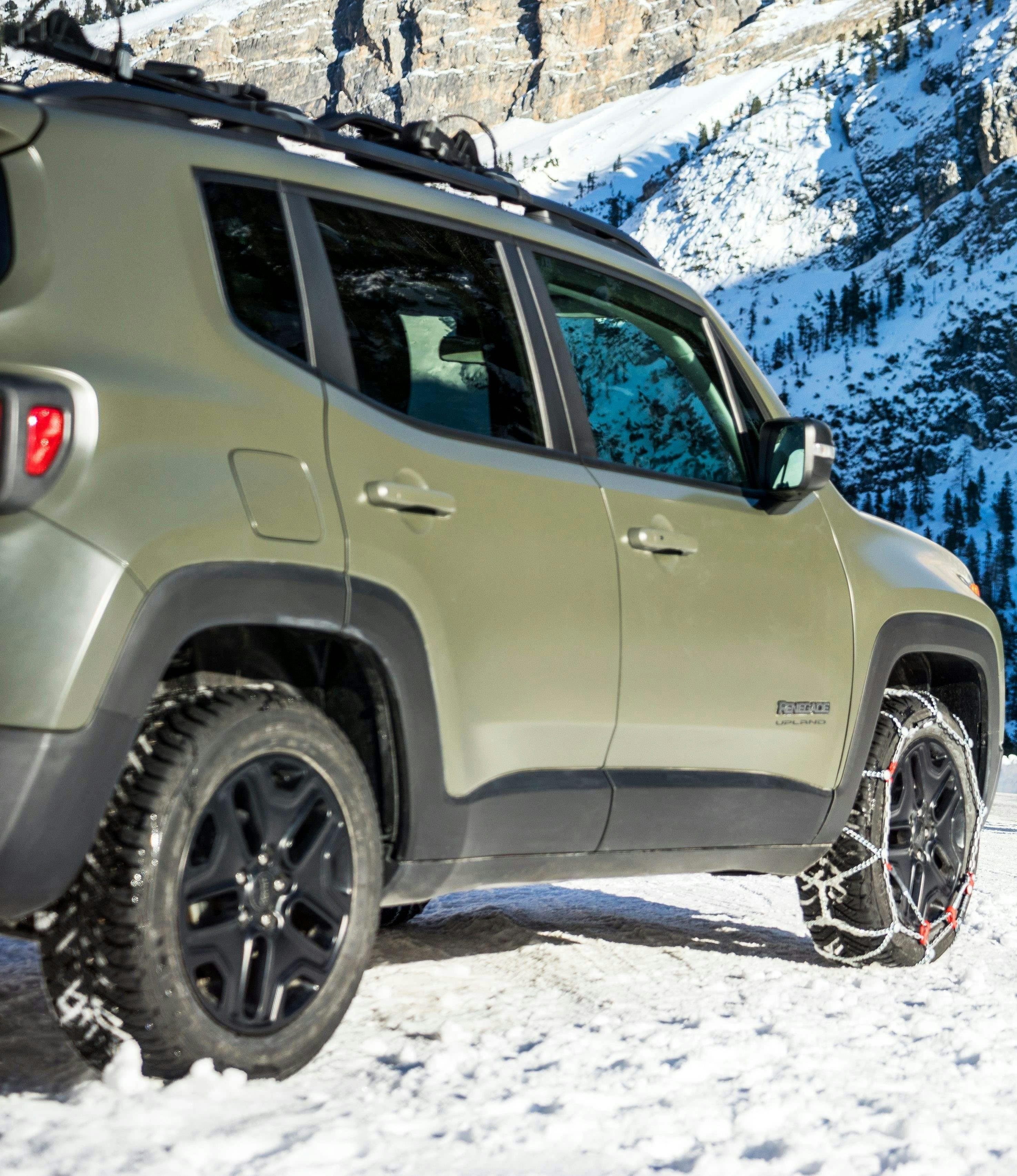 Green Jeep with snowchains fitted to tyres