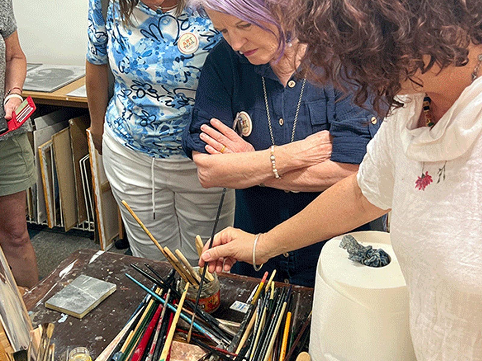 Artist discussing brushes in her studio