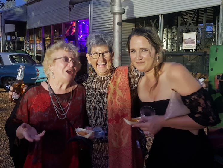 Three women at an outdoor party in Cobar enjoying a laugh