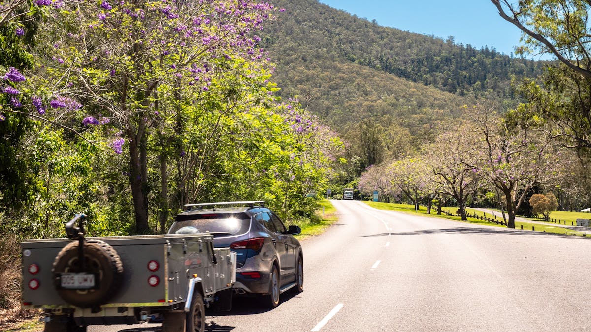 Car and campervan driving along a country road