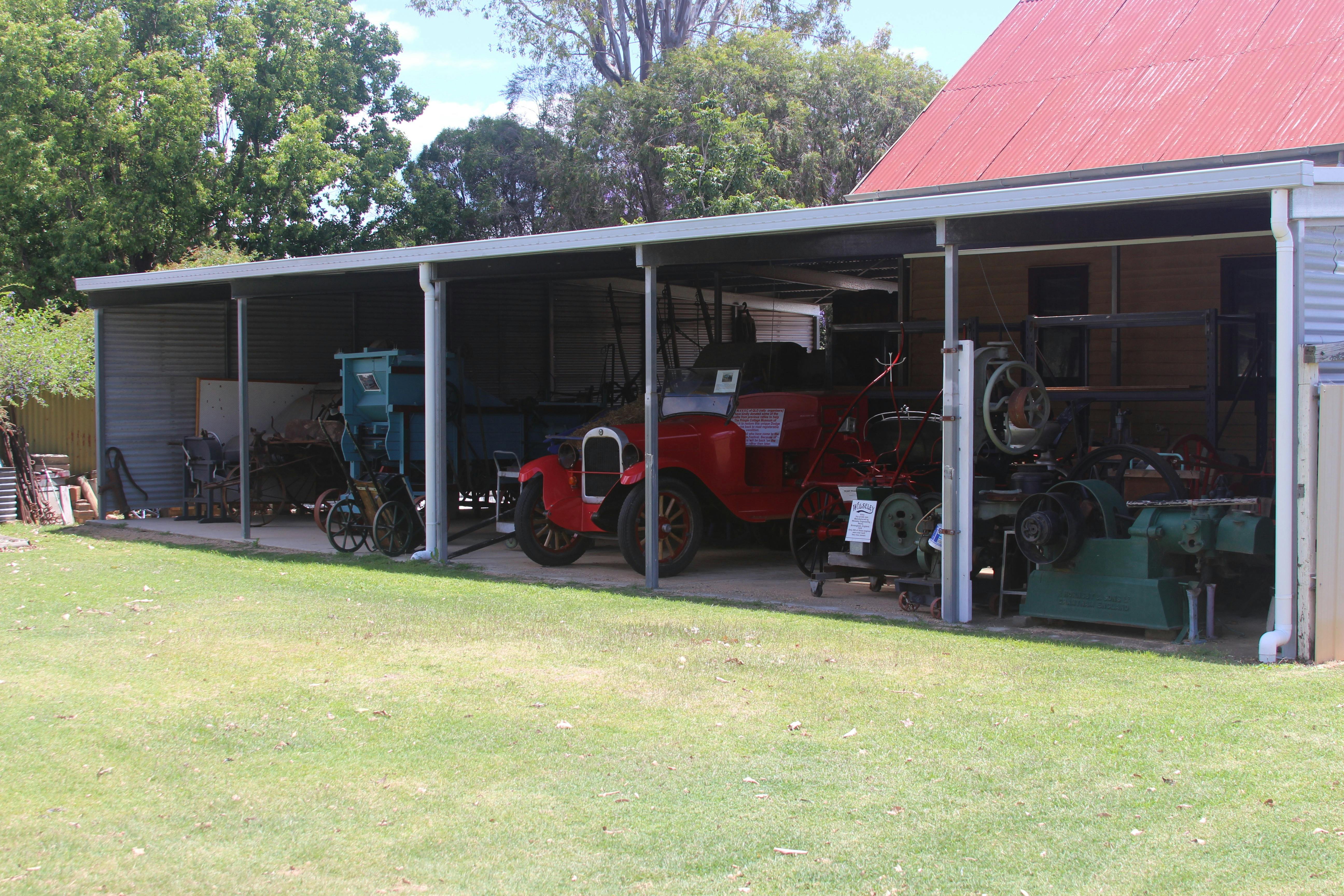 A shed containing a collection of historical farming machinery and an old fire engine.